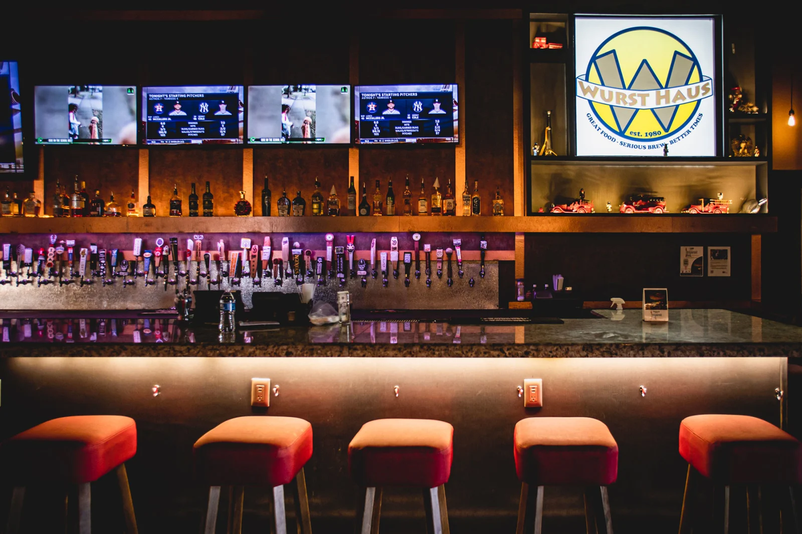 Wurst Haus’s real tap wall, illuminated sign and red stools, from the official restaurant website